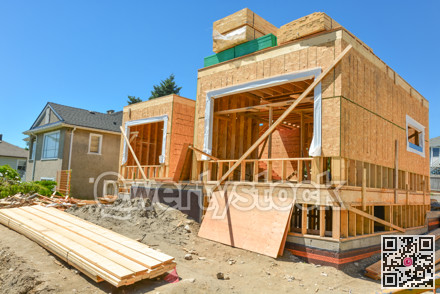New family home under construction with stacks of 2x4 timber boards on the top