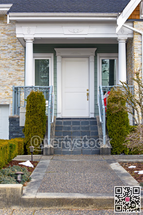 Entrance door of residential townhouse with doorsteps and pathway in front