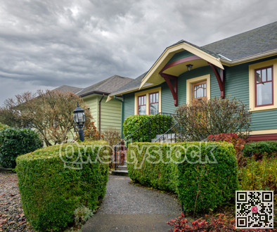 Hadge row fenced pathway and stairway of family residential house on overcast sky background