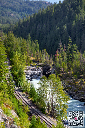 Mountain landscape with rail road and shallow river running through