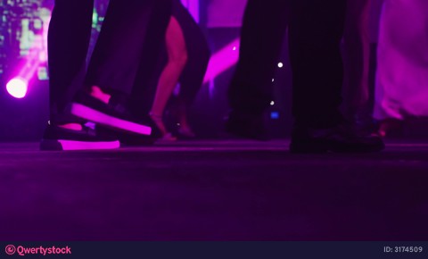 Brightly lit stage hosts dynamic dancers performing lively rhythmic routines. Vibrant scene of energetic dancers moving passionately under
